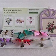 Sechs Schmetterlings-Clips und ein Stickbild
