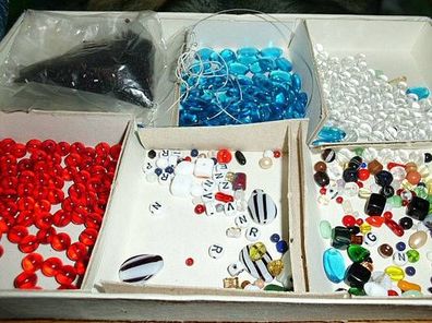 altes Kinderspiel mit verschiedenen Perlen zum Basteln von Ketten und Armbändern