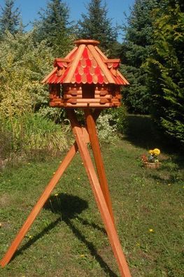 Vogelhaus mit braun - roten Holzschindeln und Gauben mit Vogelhausständer