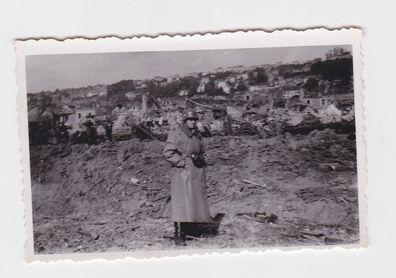 88357 Foto Deutscher Soldat im Mantel vor Häuserruinen im 2. Weltkrieg