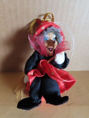 Hexe rot schwarz gekleidet auf einem Kürbis mit Aufhängung