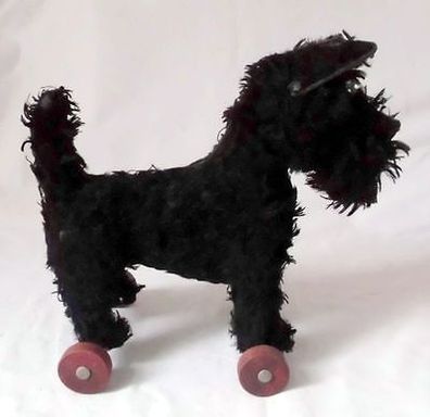 uralter schwarzer Spielzeug Hund auf Holzrädern um 1930