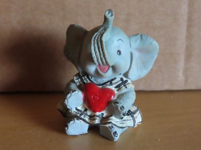 Figur Elefant sitzt mit Kleid u. Herz mit erhobenen Rüssel / ca. 5 cm hoch