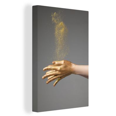 Leinwand Bilder - 80x120 cm - Frau mit goldbemalten Händen und einer Wolke aus Glitze