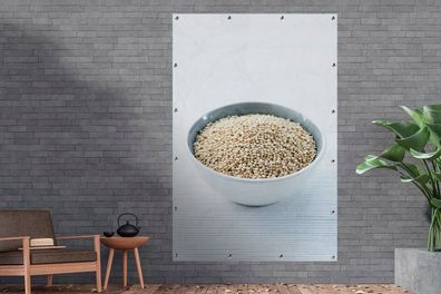 Gartenposter - 120x180 cm - Eine Porzellanschale voller Quinoa-Körner auf einem weiße