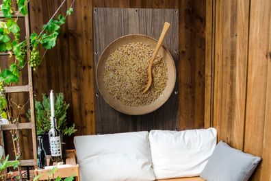 Gartenposter - 80x120 cm - Eine rustikale Holzschale mit Quinoa und Holzlöffel