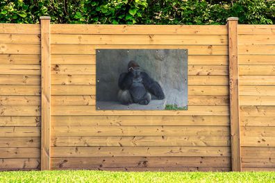 Gartenposter - 120x80 cm - Ein riesiger Gorilla lehnt an einer Steinmauer