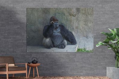 Gartenposter - 180x120 cm - Ein riesiger Gorilla lehnt an einer Steinmauer