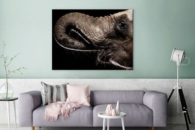 Leinwandbilder - 120x90 cm - Porträt eines Elefanten mit seinem Rüssel im Maul
