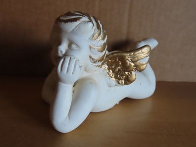 Figur Engel weiß goldene Haare und Flügel liegt auf dem Bauch und träumt