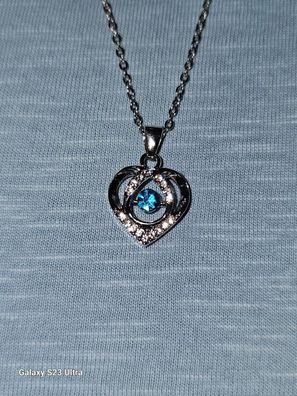 Eine Halskette Herzförmig mit Strasssteinen und einem Blauem Glücksstein
