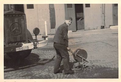 Soldat mit Kabeltrommel am Mercedes LKW